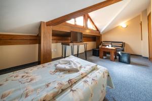 a bedroom with a bed and a tv and a chair at Kap House Family Hotel in Bansko +62 photos