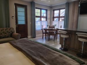 a living room with a table and a dining room at Rozenhof Guest Cottages in George