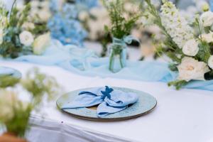 a table with a plate with a blue bow on it at Bhaya Soul - Wellness Inclusive Cruise in Ha Long