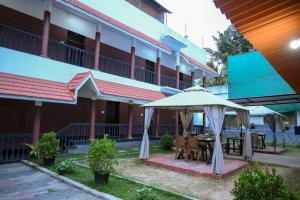 a patio with an umbrella in front of a building at Ocean Queen Palace Kovalam in Trivandrum +22 photos