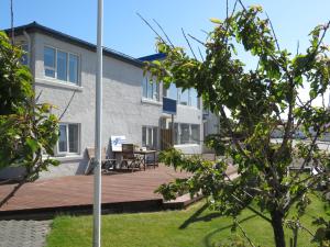 a house with a wooden deck in the yard at Old Airline Guesthouse in Höfn