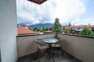 a table and two chairs on a balcony with a view at Kap House Family Hotel in Bansko