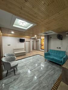a living room with two blue couches and a television at Anaya Regency in Naya Bāzār
