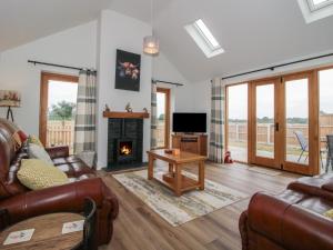 a living room with a couch and a fireplace at Chestnut Barn in Shrewsbury