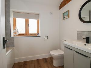 a bathroom with a toilet and a sink and a window at Chestnut Barn in Shrewsbury +28 photos