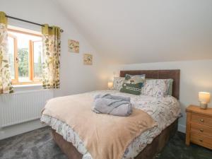 a bedroom with a bed and a window at Chestnut Barn in Shrewsbury