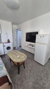 a living room with a table and a white refrigerator at Sinai st in Eilat