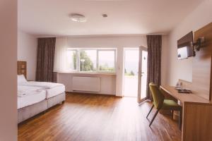a bedroom with a bed and a desk and a window at EDELFUCHS Rote-Lache in Forbach