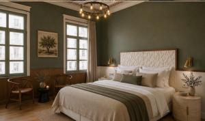 a bedroom with a large bed and two windows at Sekeria Hammam & Suites, Historic Mansion Hotel in Heraklio