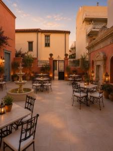 an outdoor patio with tables and chairs and a fountain at Sekeria Hammam & Suites, Historic Mansion Hotel in Heraklio