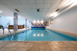 a swimming pool with blue water in a building at Kap House Family Hotel in Bansko