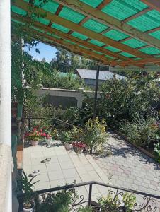 a patio with potted plants and a wooden pergola at House in the forest in Tyup