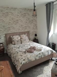 a bed in a bedroom with a stone wall at Chambre chez l'habitant "lou Castanier" in Cayrols