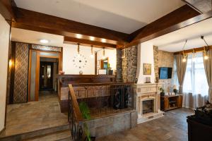 a living room with a fireplace and a tv at Kap House Family Hotel in Bansko