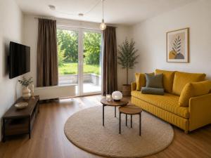 a living room with a yellow couch and a table at Apartment Alex in Pirna