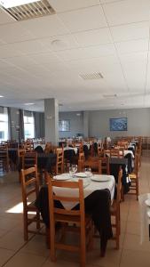 a dining room with tables and chairs in a room at Hotel Avenida del Sotillo in La Lastrilla