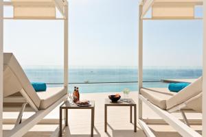a living room with two white chairs and a table at Hotel Best Oasis Tropical in Mojácar +124 photos