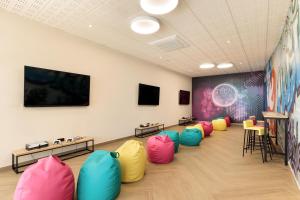 a waiting room with colorful chairs and a large screen at Hotel Best Oasis Tropical in Mojácar