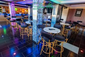 a bar with tables and chairs in a restaurant at Shanvilla Resort Ltd in Murangʼa