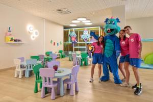three people standing next to a mascot in a classroom at Hotel Best Oasis Tropical in Mojácar