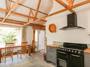 a kitchen with a stove and a table with chairs at Little Orchard in Swallowcliffe