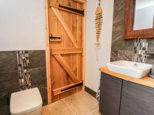 a bathroom with a wooden door and a sink at Little Orchard in Swallowcliffe +14 photos