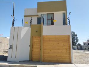 a house with a wooden garage door at Casa Almara - Ica in Ica