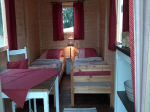a room with two beds and a table in a cabin at Schäferwagen Weidetraum in Naila