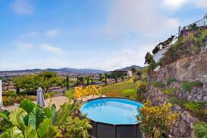 a swimming pool in a garden next to a mountain at Casa de Limon in Cerrogordo