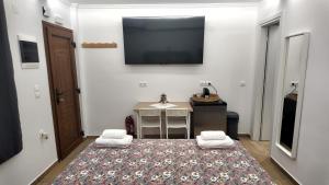 ein Zimmer mit Fernseher und einem Tisch mit Teppich in der Unterkunft T.G. Corfu Studios in Korfu-Stadt