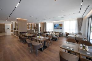 a restaurant with tables and chairs in a room at Hotel By Holiday in Rinas