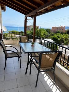 a table and chairs on a balcony with a view of the ocean at Villa Theodora 30m from the beach in Egira