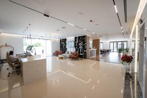 an office with a lobby with a desk and chairs at Hotel By Holiday in Rinas