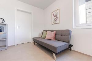 a couch with a pink pillow in a living room at Bluemlisalp Studio - Aare Jungfrau AG in Spiez +6 photos