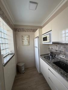 a kitchen with a sink and a white refrigerator at Apartamento turístico ilusiones 5 in Cazalla de la Sierra +2 photos