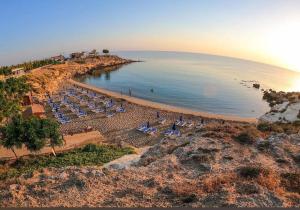 an aerial view of a beach with chairs and the ocean at Villa Artemis - 150m from Kapparis Beach in Paralimni