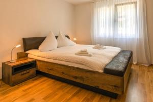 a bedroom with a large bed with white sheets and a window at Moench Apartment - Aare Jungfrau AG in Wilderswil