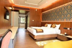 a bedroom with a large bed and a table at IJ Crowne in Mysore +39 photos