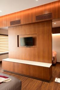 a living room with a tv on a wall at IJ Crowne in Mysore