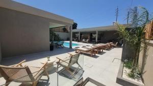 a patio with tables and chairs next to a pool at Elysian Residences Heraklion in Heraklio