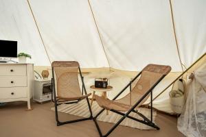 two chairs and a table in a tent at Tipi Jurte Zelt in der Seenplatte in Carpin