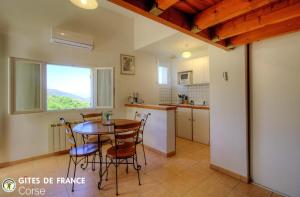 a kitchen and dining room with a table and chairs at Mezzana in Taglio-Isolaccio