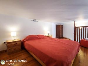 a bedroom with a bed with a red bedspread at Mezzana in Taglio-Isolaccio