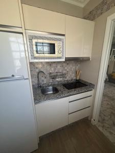 a kitchen with a sink and a microwave at Apartamento turístico ilusiones 5 in Cazalla de la Sierra