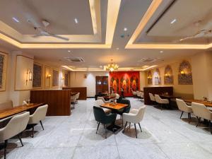 a restaurant with tables and chairs in a room at Hotel janki elite in Jaipur