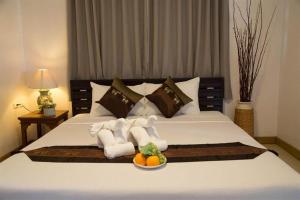 a bed with towels and a bowl of fruit on it at EASTAN VIEW in Chiang Mai
