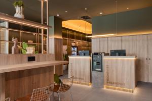 a lobby with two chairs and a cash register at B&B HOTEL Murcia Thader in Churra