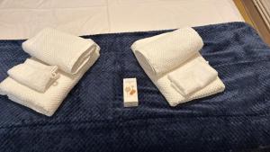 two towels and a bar of soap on a bed at Azur des jardins in Annonay +2 photos
