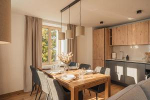 a kitchen and dining room with a wooden table and chairs at Residenza Tilia in San Bernardino