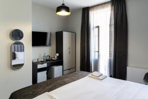 a bedroom with a white bed and a window at Corner House in Lovech